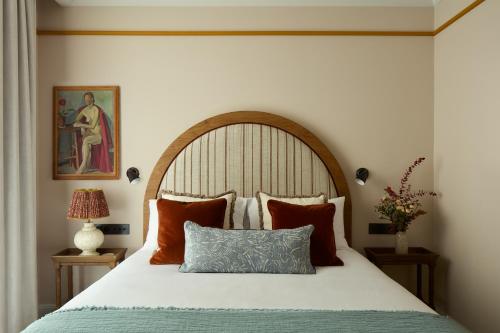巴黎Le Grand Hôtel Cayré的一间卧室配有一张带木制床头板和枕头的床。