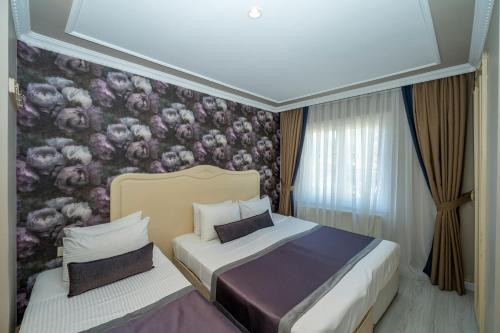 伊斯坦布尔雷蒙德酒店的一间卧室设有两张床和花卉壁纸