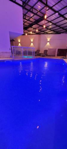 TigzirtImmeuble Thala Tigzirt Duplex de 135m avec 2h de piscine en privé的一座大型蓝色游泳池,位于一座灯光明亮的建筑中