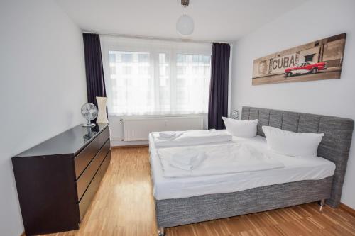 柏林Apartment Isabella的一间卧室配有一张床、一张书桌和一个窗户。