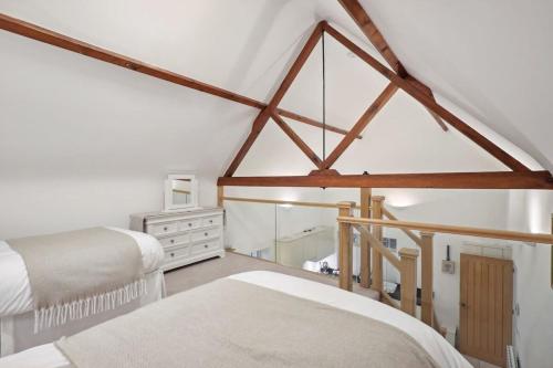 哈波罗集市Squirrel Lodge - 2 Bed Country Home的阁楼卧室配有两张床和镜子