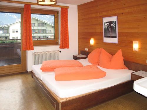 迈尔霍芬Holiday Home Mariandl - MHO103 by Interhome的一间卧室配有带橙色枕头的床和窗户。