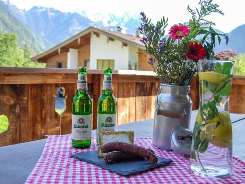 奇勒谷地拉姆绍Holiday Home Geislerhütte - MHO685 by Interhome的一张桌子,上面放着两瓶葡萄酒和一盘食物