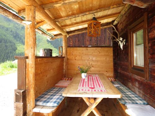 希帕赫Chalet Simonhütte - MHO640 by Interhome的小木屋的门廊,配有野餐桌