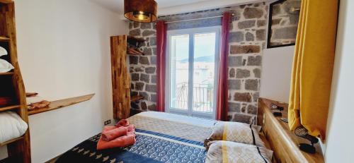 阿雅克修Magnifique appartement avec balcon vue mer à l'entrée d'Ajaccio的一间卧室设有石墙和窗户。