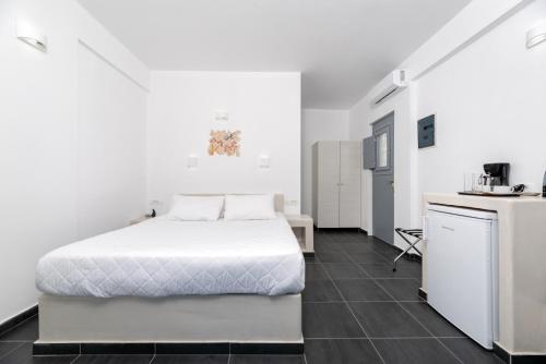 阿克罗蒂里潘珂丽珊酒店的一间带白色床的卧室和一间厨房