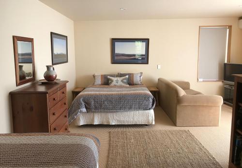 瓦纳卡Sargood Splendour - Wanaka Holiday Home的一间卧室配有一张床、一张沙发和一把椅子