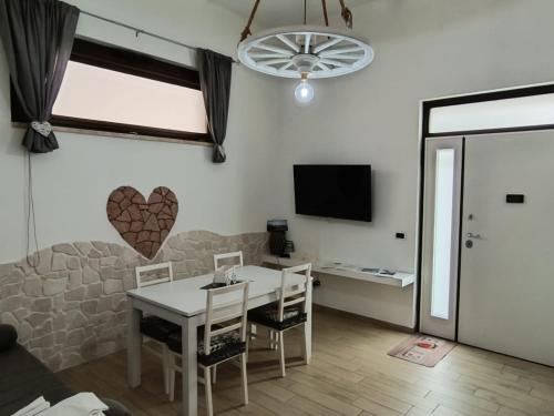 滨海波利尼亚诺House Mami的客厅配有桌椅和电视。