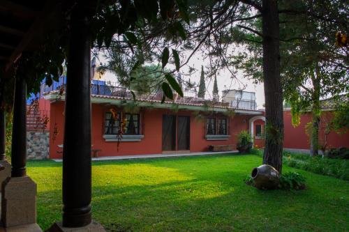 危地马拉安地瓜Santa Margarita的前面有树木的红房子