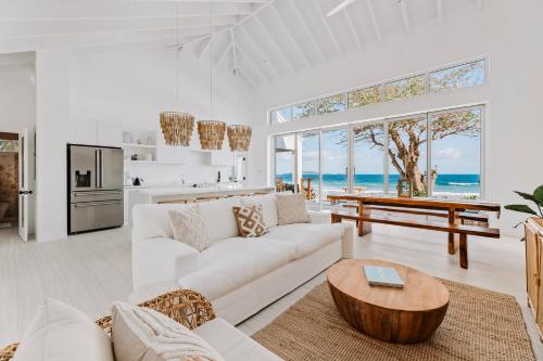 Tortola IslandLong Bay Beach Resort的客厅配有白色的沙发和桌子