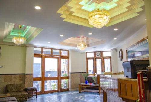 穆索里Hotel Abhinandan Mussoorie Near Mall Road - Parking Facilities & Prime Location - Best Hotel in Mussoorie的客厅的天花板上设有2个吊灯。