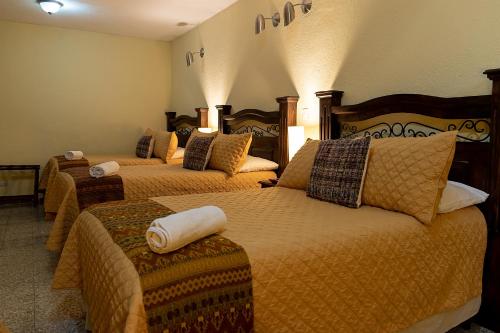危地马拉Hostal Donde Regina的一间酒店客房,房间内设有三张床