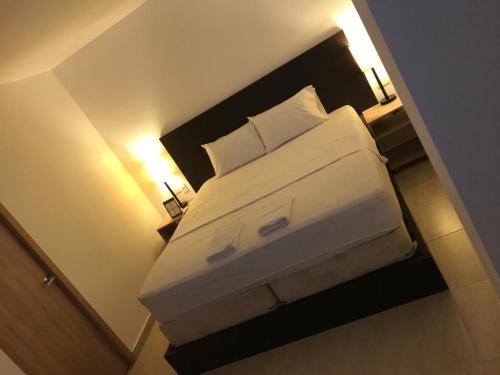 麦德林Hotel Medellin op的一张位于酒店客房的床位,配有两盏灯