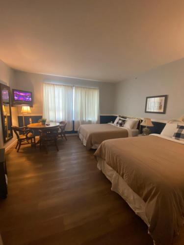 奇利瓦克Royal Hotel Chilliwack的酒店客房设有两张床和一张桌子。