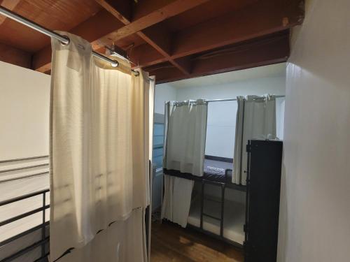 洛杉矶Roomi的带淋浴帘和窗户的浴室