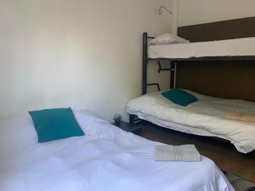 墨西哥城Hermosa Habitación con balcon cama mat y litera Polanco的配有两张双层床的客房配有白色床单和蓝色枕头