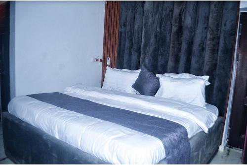 阿布贾Empire Suites And Apartment的一张配有白色床单和枕头的大床