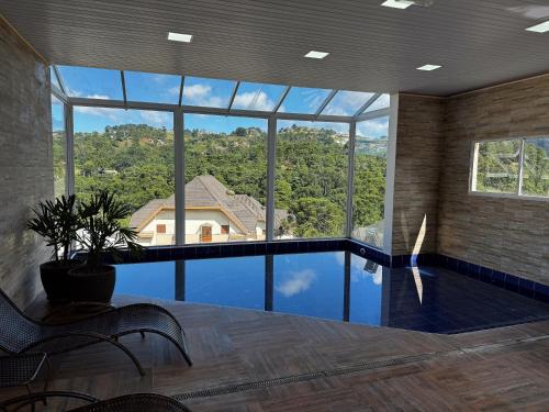 坎波斯杜若尔当Pousada Kaliman Premium的大型客房设有带大窗户的游泳池