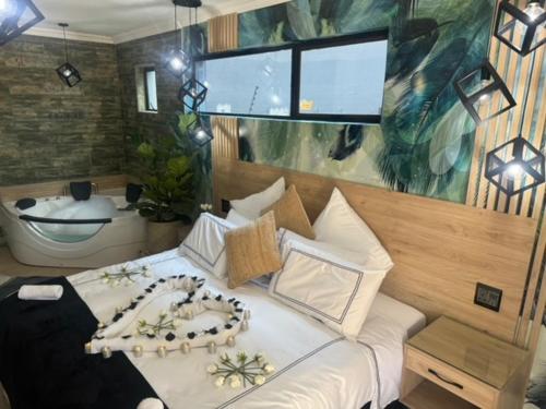 伯诺尼Africa Paradise - OR Tambo Airport Boutique Hotel的一间卧室设有一张大床和一个浴缸