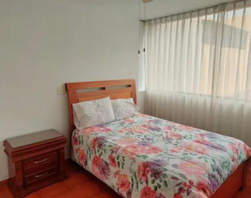 利马Hermosa Casa en el Polo的一间卧室配有一张带花卉棉被的床