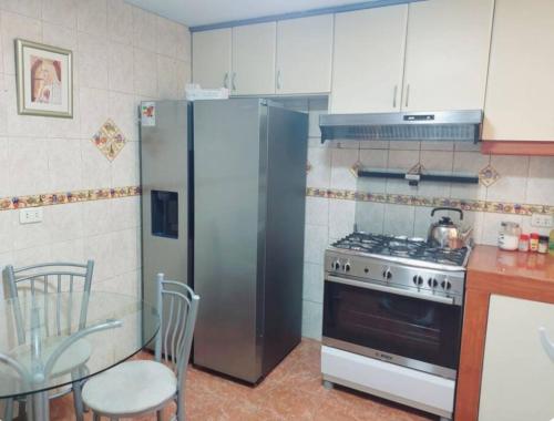 利马Hermosa Casa en el Polo的厨房配有不锈钢冰箱和桌子