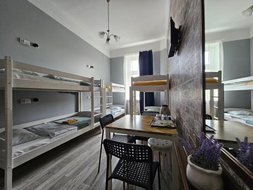 华沙Deja Vu Hostel的客房设有餐桌和双层床。