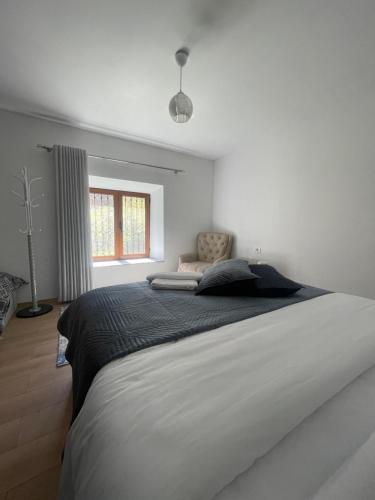 BogëPaja Guesthouse - Camping的白色卧室设有一张大床和窗户