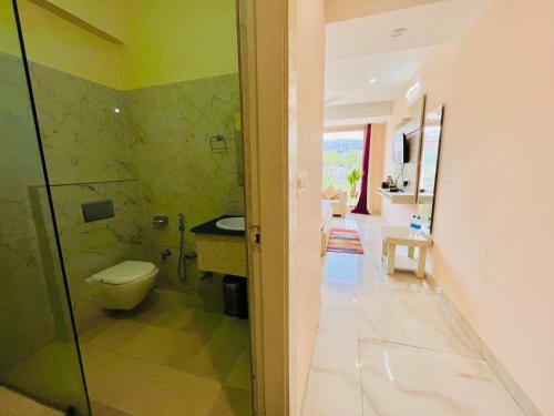 哈里瓦Hotel The Tirath View的一间带卫生间和玻璃淋浴间的浴室