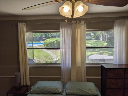 坦帕Executive Pool Home的卧室设有窗户和吊扇