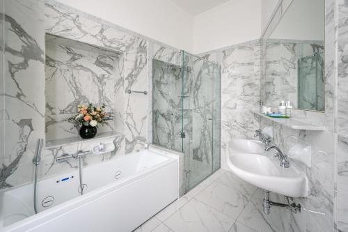 贝拉吉奥Grand Hotel Villa Serbelloni - 150 Years of Grandeur的白色的浴室设有水槽、浴缸和浴缸。