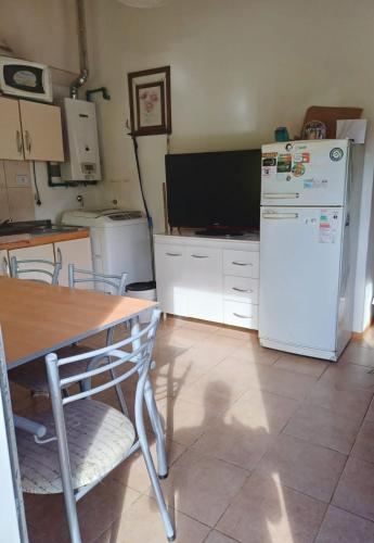 乌斯怀亚El Amanecer的厨房配有桌子和白色冰箱。