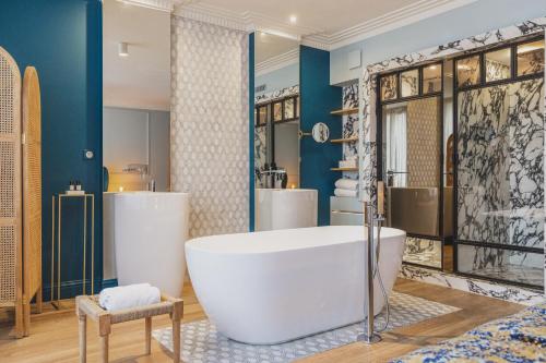 波尔多Hôtel Singulier Bordeaux的一间带大浴缸和两个盥洗盆的浴室