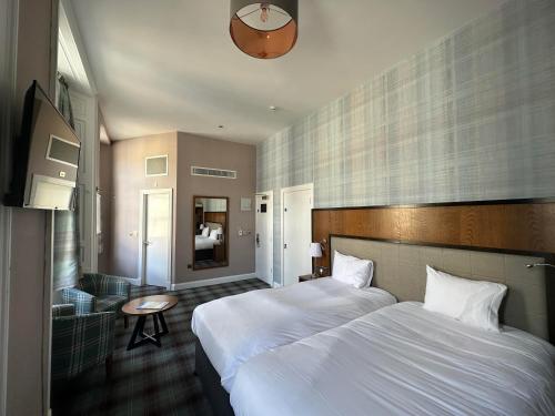 邓弗姆林市政厅和亚麻交易所威瑟斯本酒店的酒店客房设有两张床和一张桌子。