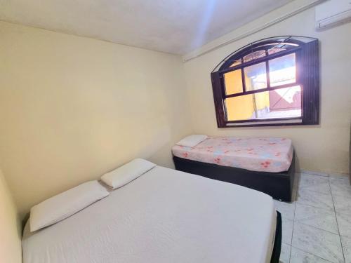 阿拉亚尔-杜卡布Casa Praia Grande - Arraial do Cabo的一间小卧室,配有两张床和窗户