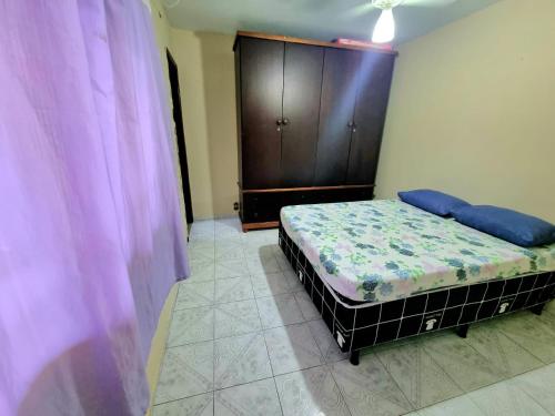 阿拉亚尔-杜卡布Casa Praia Grande - Arraial do Cabo的一间卧室配有一张床和一个木制橱柜