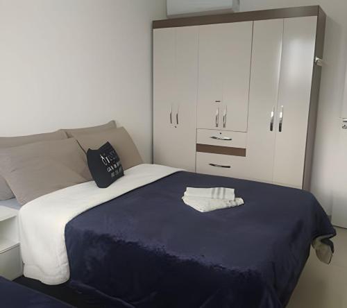纳韦甘蒂斯Captiva Beach - 400m da PRAIA - WiFi - Netflix - Residencial Captiva的一间卧室配有一张带蓝色毯子和白色橱柜的床。