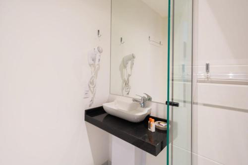 圣保罗BHomy Brooklin - 300m estacão da Brooklin BUR101的一间带水槽和玻璃淋浴的浴室