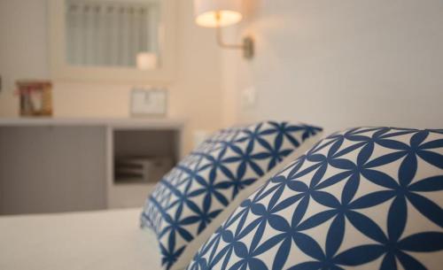 埃斯普霍斯Hotel Rosamar - Emar Hotels的房间里的床上有蓝色和白色的枕头