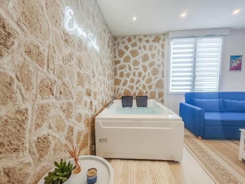 勒阿弗尔Évasion Santorin - Jacuzzi & Relax的客厅设有蓝色的沙发和墙壁。
