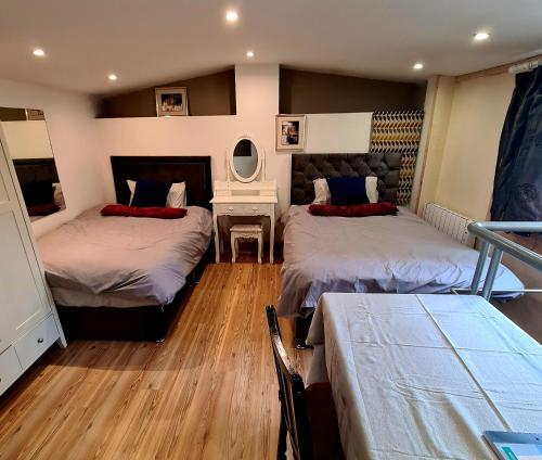 都柏林The Lodge的一间卧室配有两张床、一张桌子和一面镜子