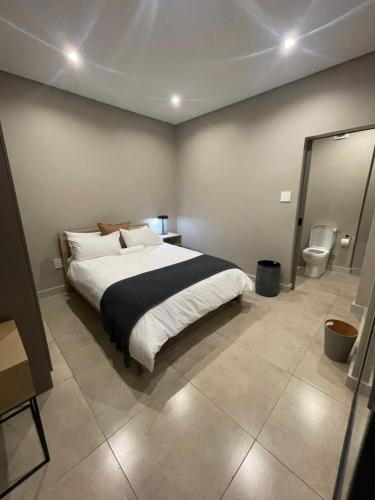 约翰内斯堡On Fredman Drive的一间卧室设有一张大床和一个卫生间