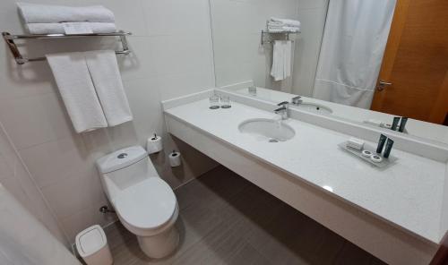 圣地亚哥Hotel Diego de Almagro Pudahuel Aeropuerto的白色的浴室设有卫生间和水槽。