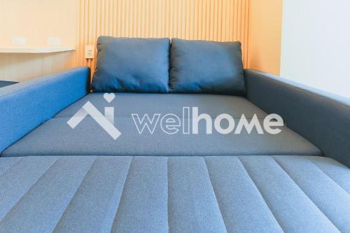 科蒂亚Aconchegante apartamento em Cotia的蓝色的沙发,上面有欢迎的标志