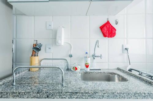 圣保罗BHomy Pompéia Muito bem localizado FI33的一个带水槽和红色钱包的厨房台面