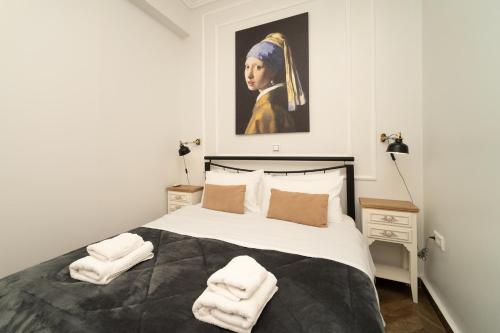 皮洛斯villa Chris的卧室配有一张大床,墙上挂有绘画作品