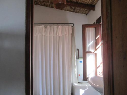 蒂尔卡拉La Calabaza Cabaña的浴室设有白色的淋浴帘和水槽