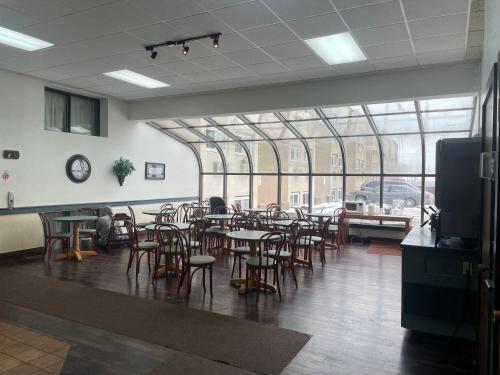 迈诺特Dakota Inn的一间带桌椅的用餐室和大窗户