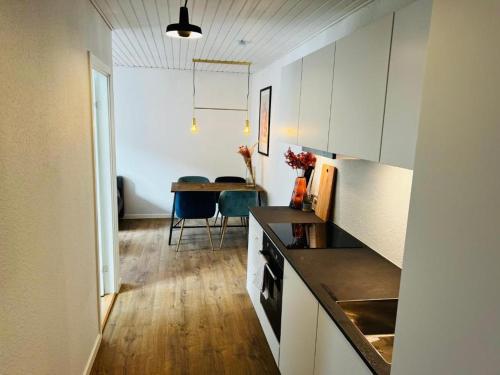锡尔克堡The Old Hotel Silkeborg - 1MTH的一间厨房,内设白色橱柜和一张桌子