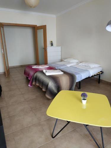 阿尔布费拉Edifice Ibérico的配有黄色桌子的客房内的两张床