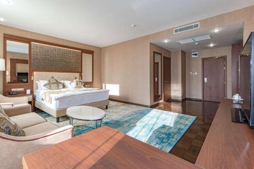 阿斯塔纳阿斯塔纳贝斯特韦斯特酒店的一间卧室设有一张床和一间客厅。